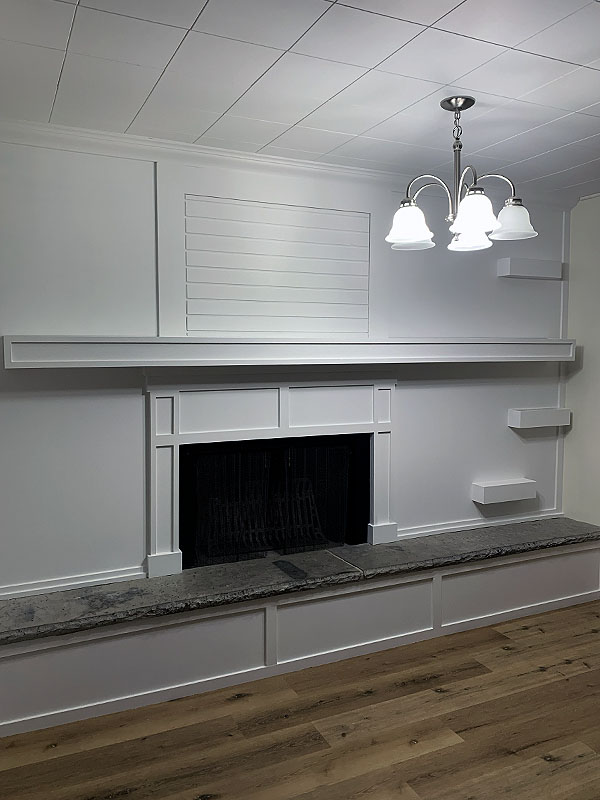 Custom fireplace mantle and wall creation by Y&R Construction.